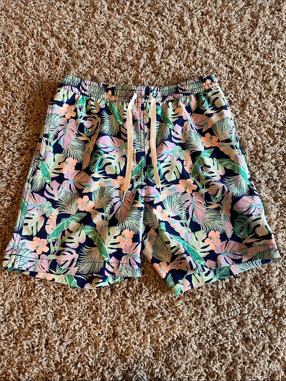 Chubbies youth medium swim trunks with a navy blue base floral print.